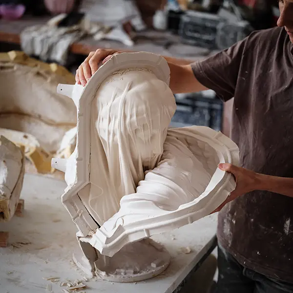 A view in the workshop: our artisan is removing the mold from a cast of the Veiled Virgin