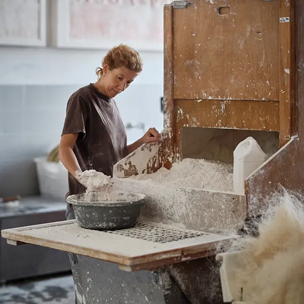 Prise de vue dans l’atelier de moulage. Notre artisan, devant la réserve de plâtre