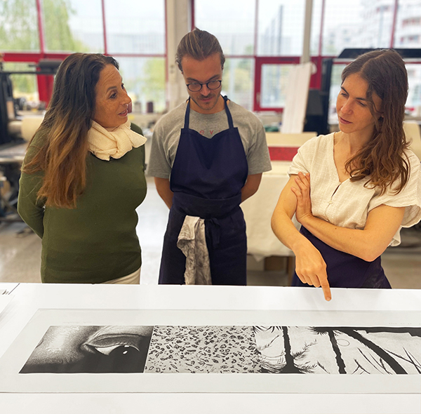 Carole Benzaken dans l'atelier de chalcographie face au tirage de son estampe en discussion avec nos deux artisans Lucile et Marius
